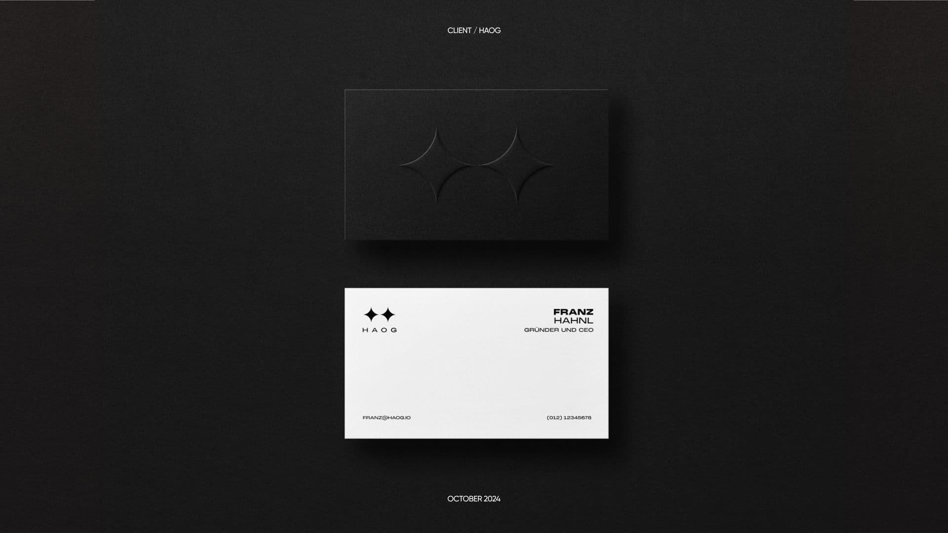 Black and white business cards with the HAOG logo on a dark surface
